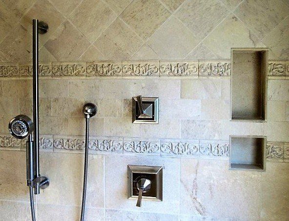A shower with a tiled wall and a shower head