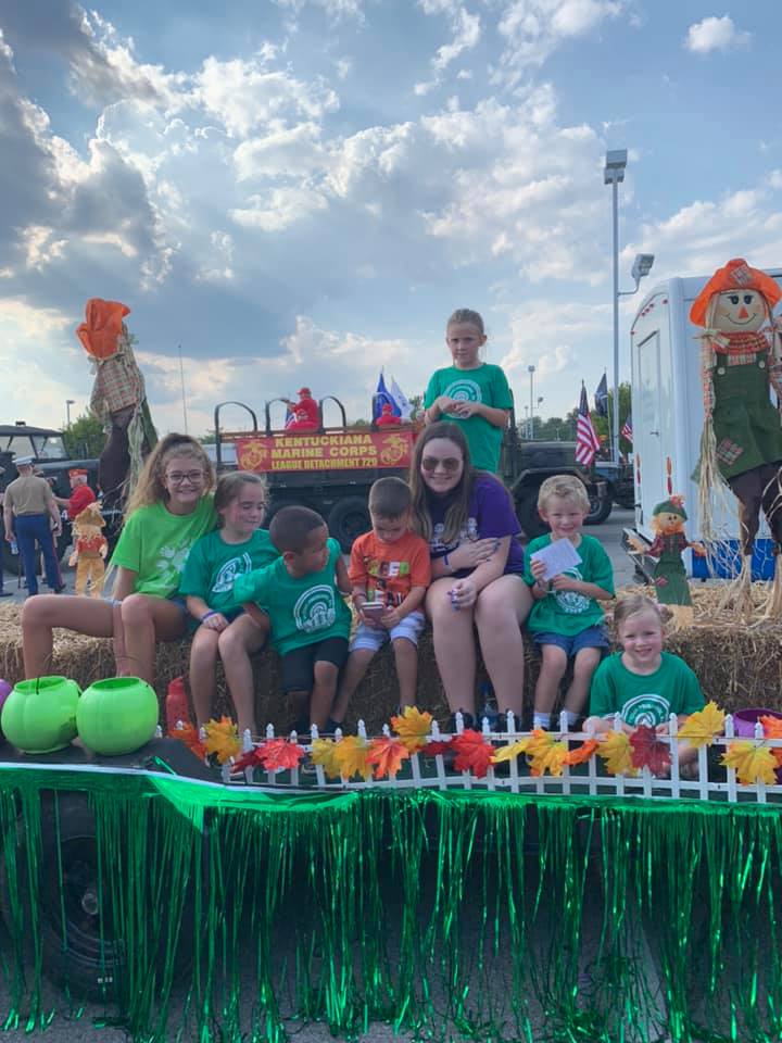 A group of children are sitting on a float in a parade.