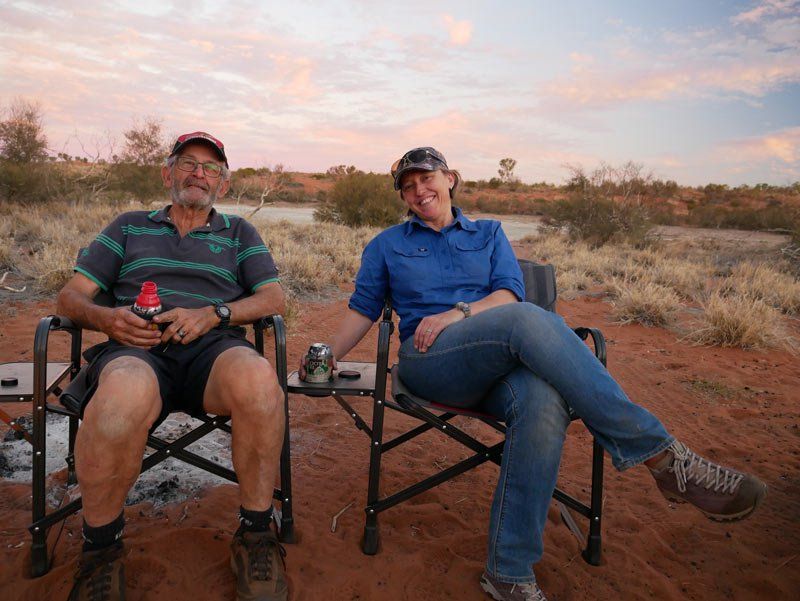 two people sitting in chairs in the desert