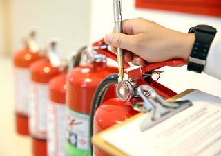 Fireman Checking the Fire Extinguisher — Cayman Islands — Advance Fire & Plumbing Ltd Fireman Checking the Fire Extinguisher — Cayman Islands — Advance Fire & Plumbing Ltd
