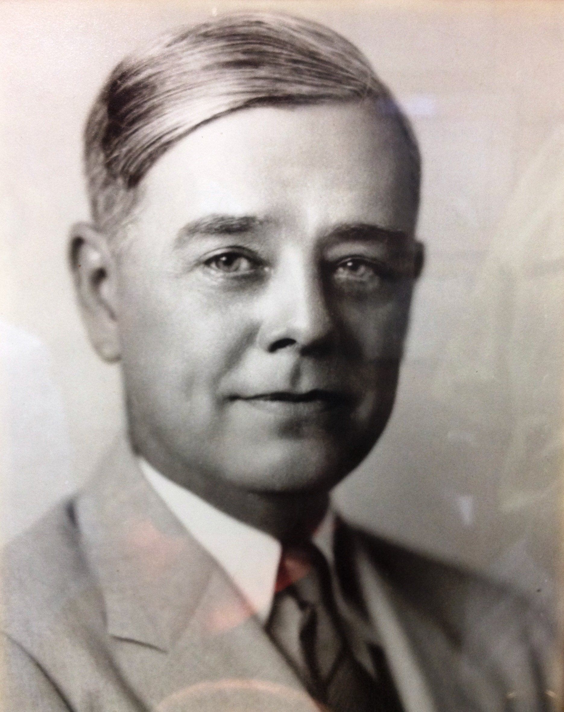 A black and white photo of a man in a suit and tie