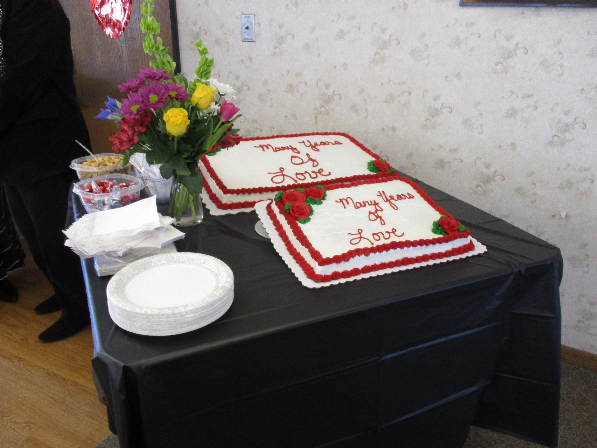 Two cakes on a table that say many years of love