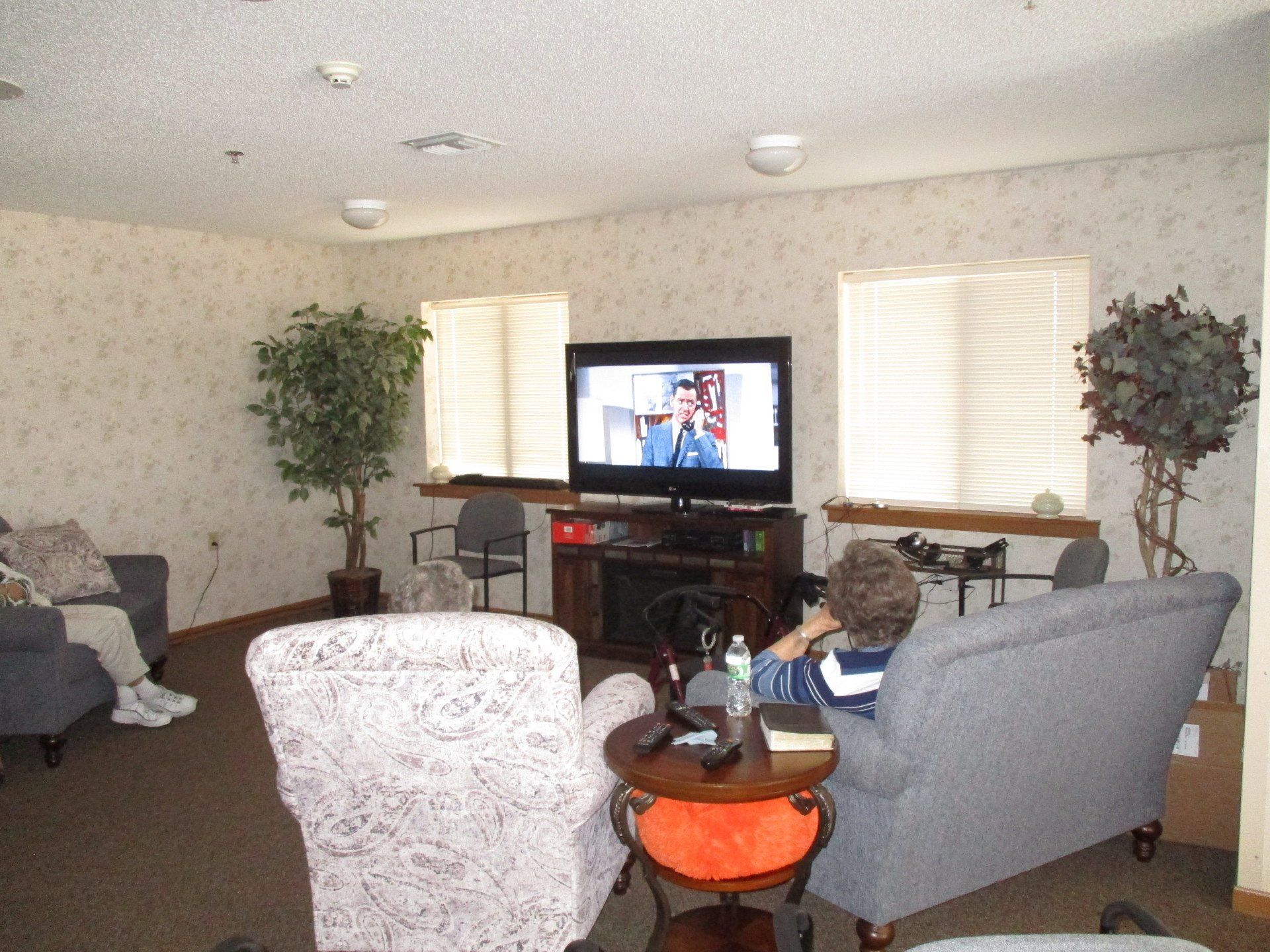 A man sits on a couch in front of a flat screen tv