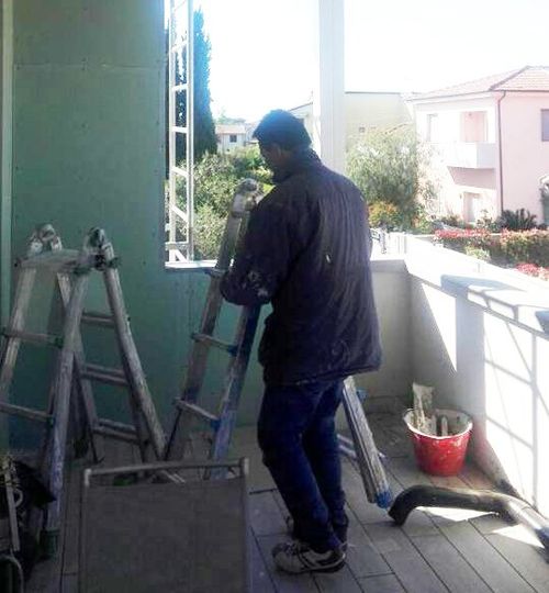 un uomo su un balcone e delle piccole scale in ferro