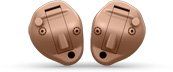 A pair of hearing aids are sitting next to each other on a white surface.