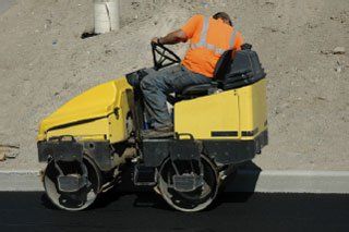 Man on Small Asphalt Paver — Kent, WA — Acme Paving & Seal Coating, Inc.
