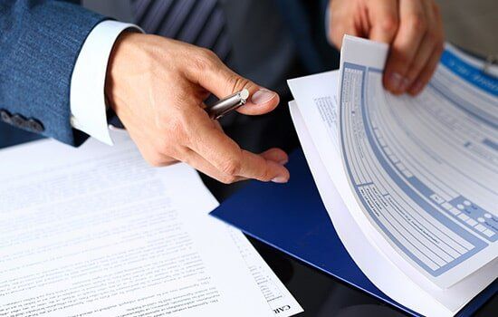 Insurance Agency — Man Holding Insurance Form in Corrales, NM
