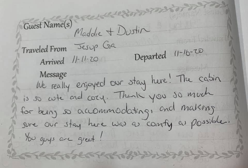 Guestbook note praising a cabin stay, handwritten on a decorative paper form.