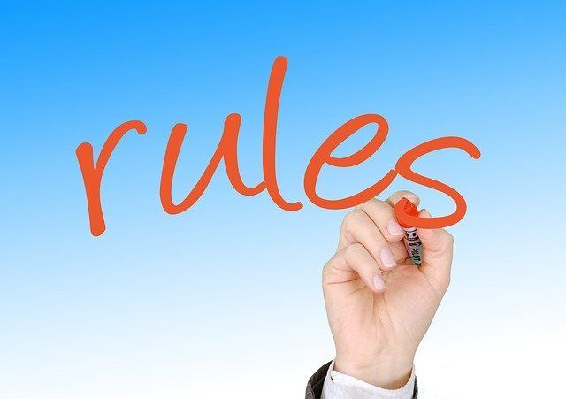 Hand writing “rules” in orange on a blue background