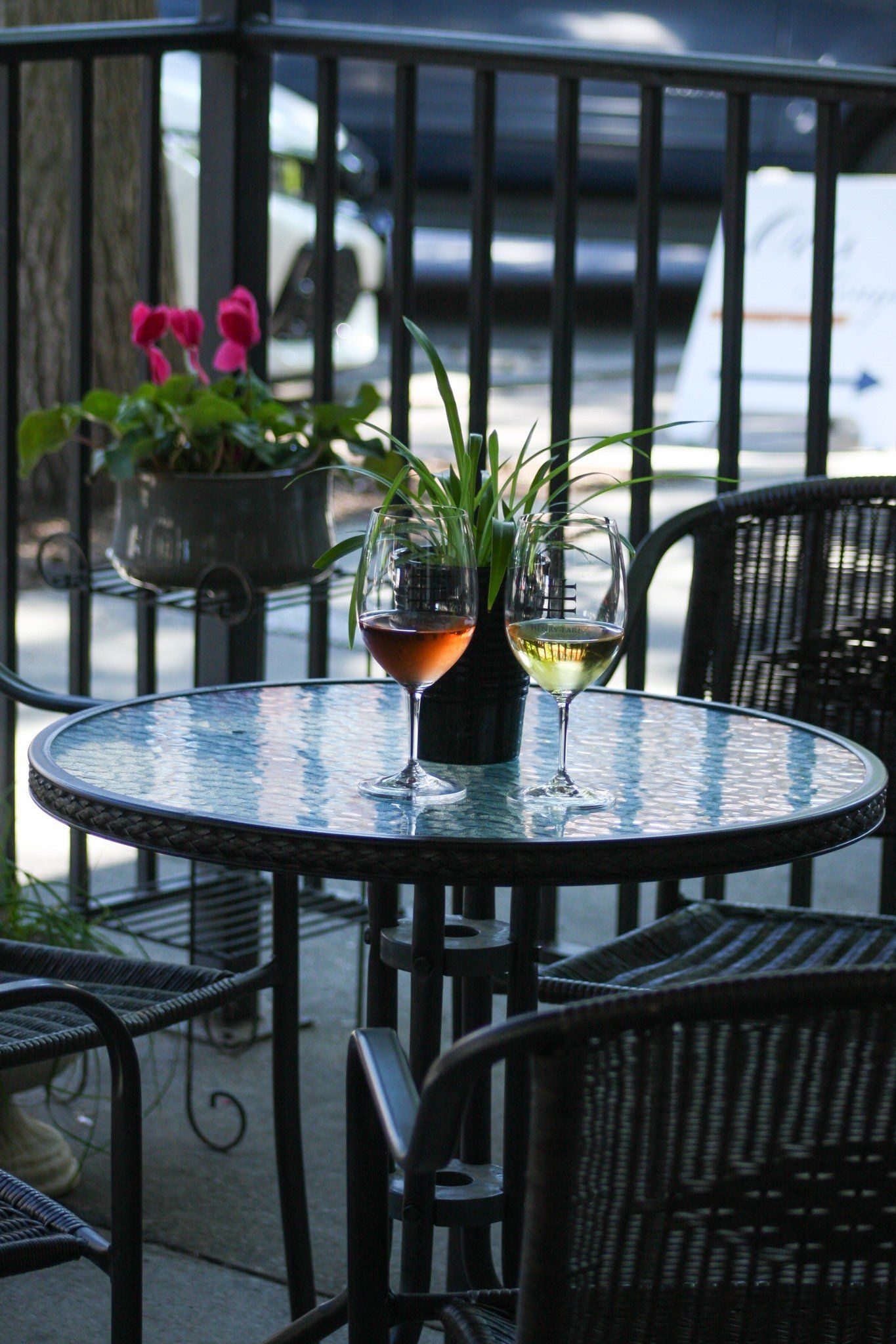 A table with two glasses of wine and a vase of flowers on it