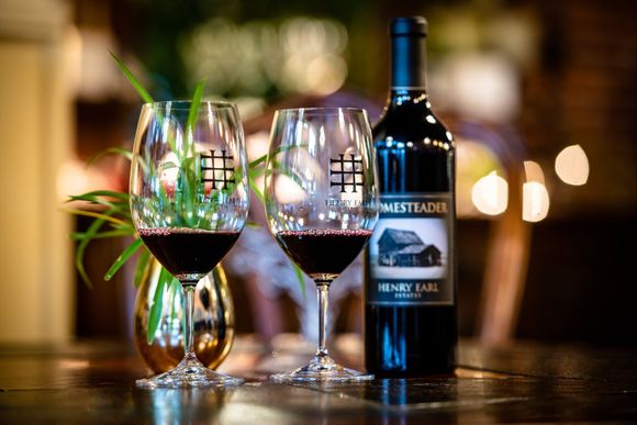 A bottle of wine and two glasses of wine are on a table.