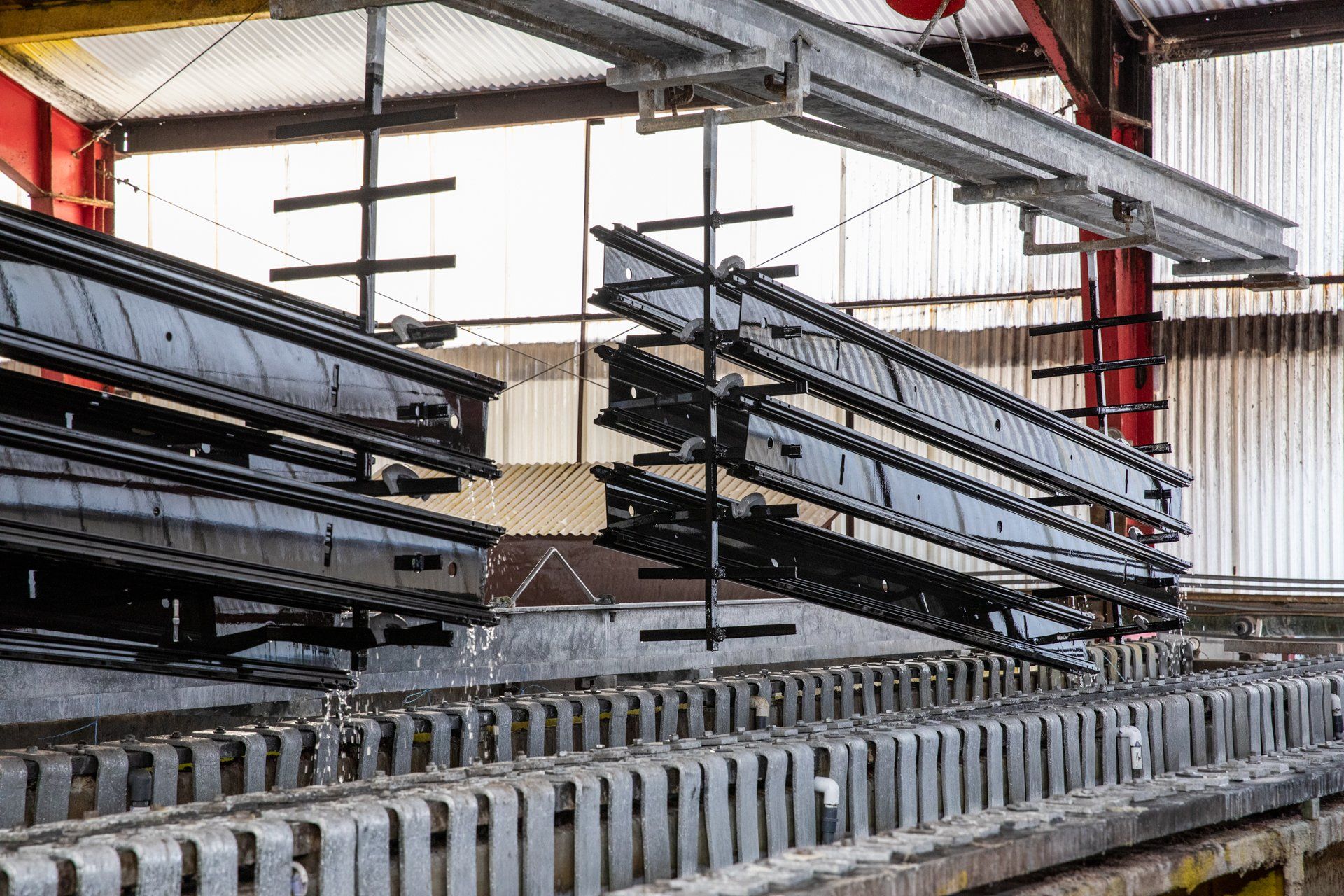 large pieces of metal being dipped lifted for anodizing