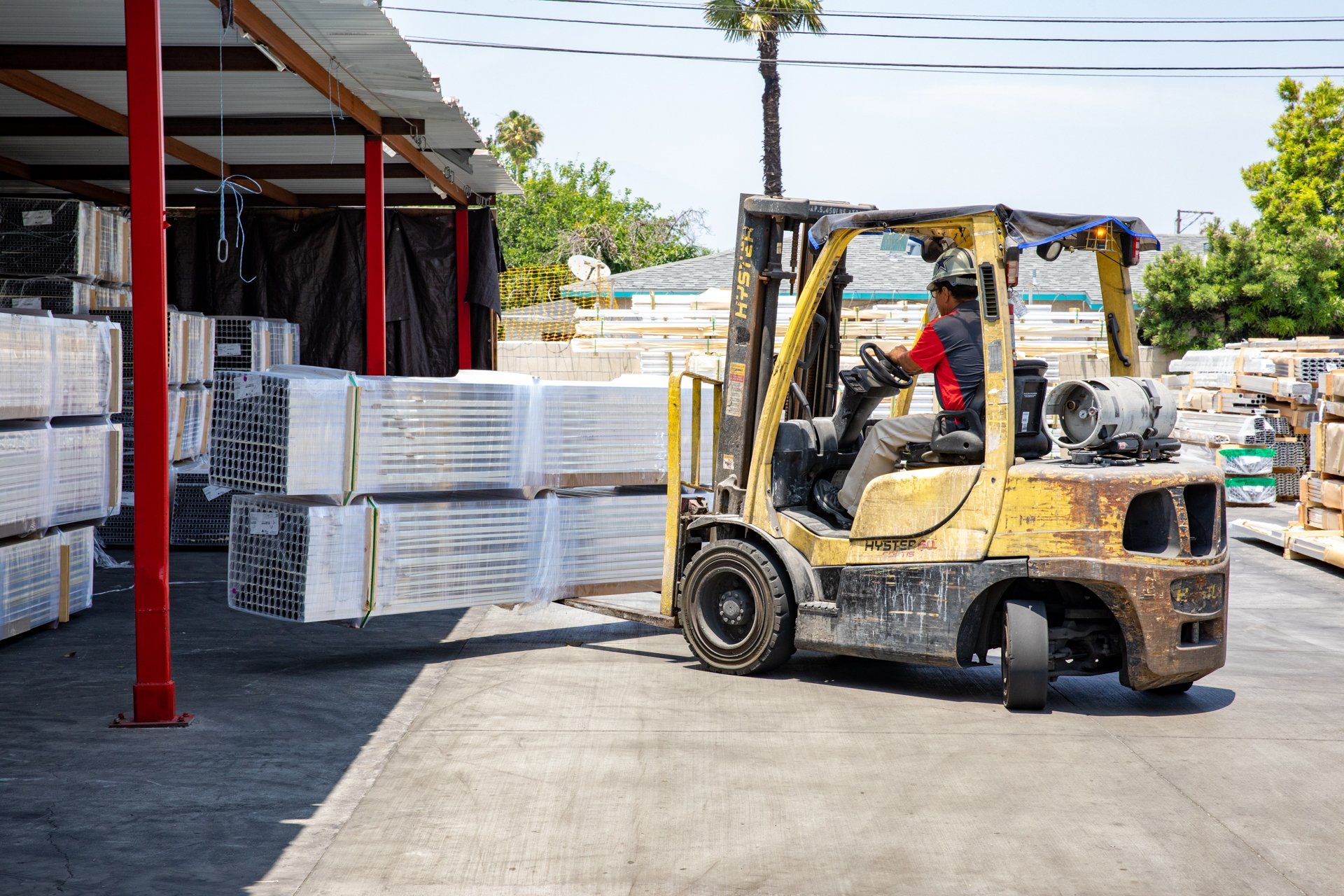 forklift moving large bundle of metal outside