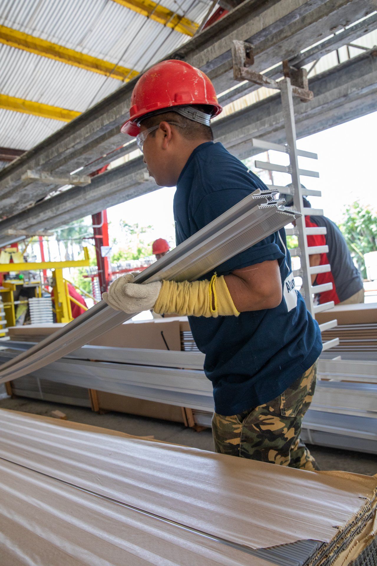 man with hard hat lifting long metal