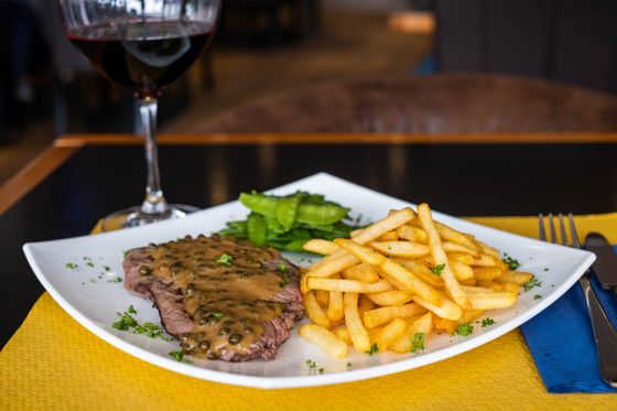 Un steak et des frites accompagnés d'une salade verte