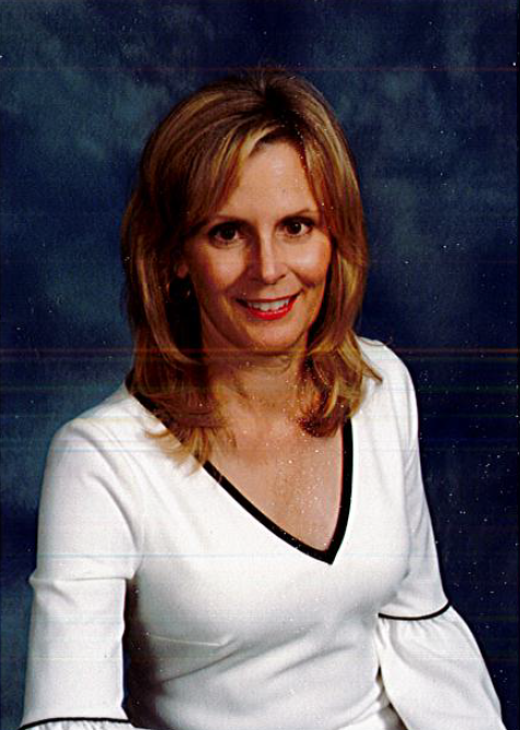 Studio portrait of a smiling woman in a white top against a blue background