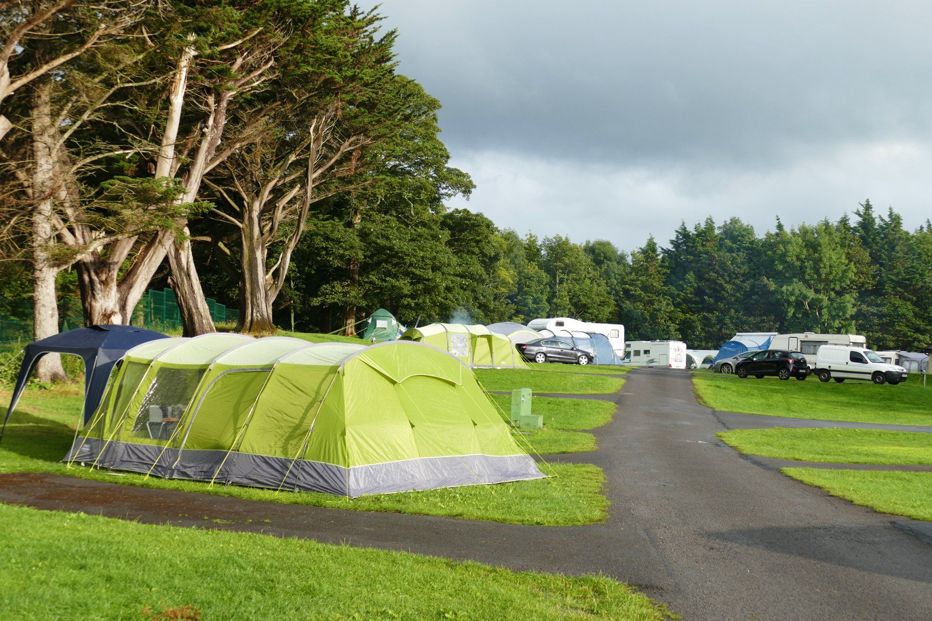 A group of tents are sitting on top of a lush green field.