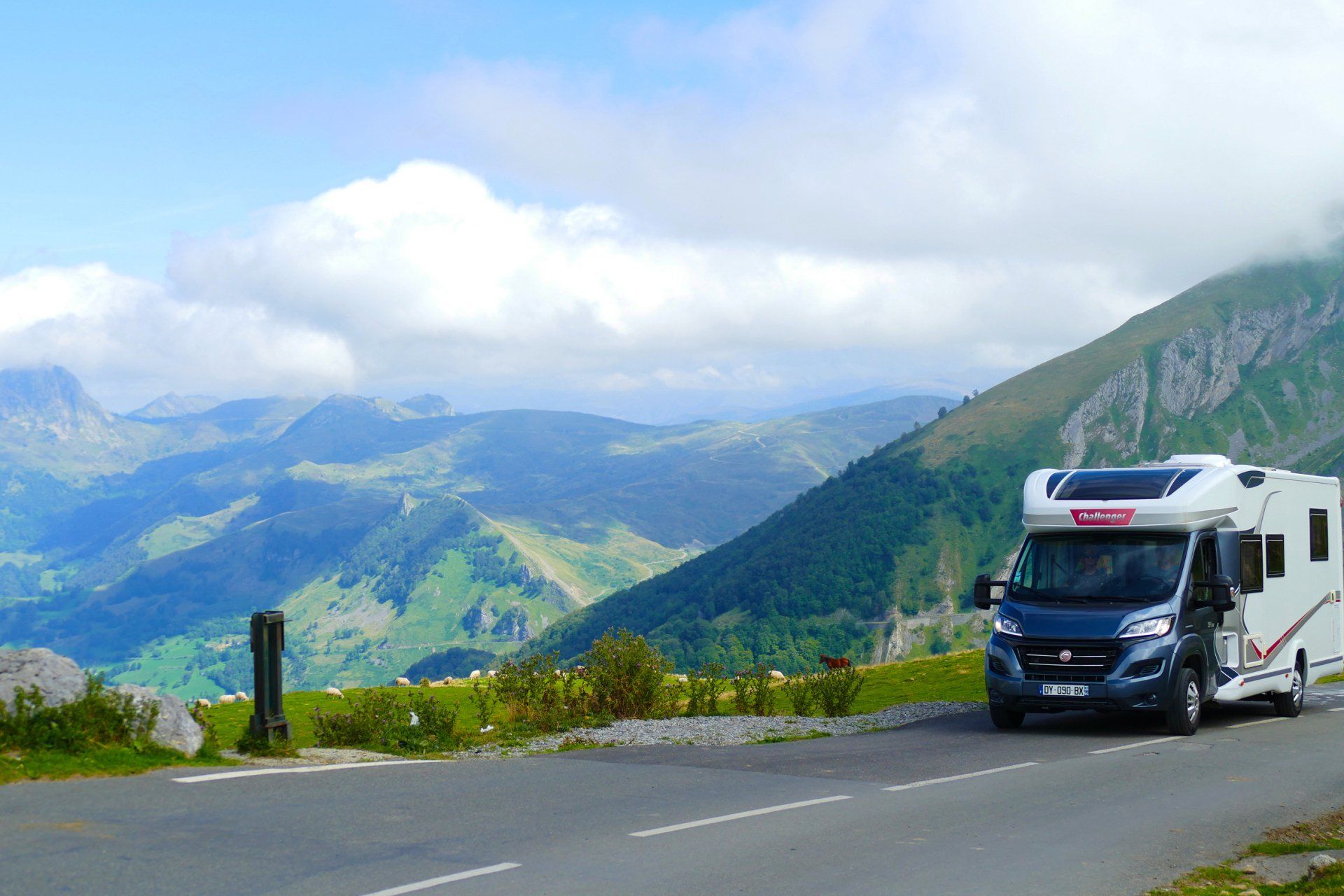 A motorhome is driving down a mountain road in France