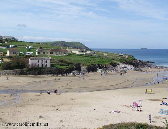 A picture of a beach in Cornwall with a campsite beside