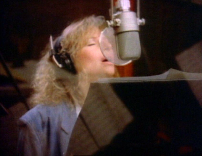 Streisand singing at microphone for The Broadway Album.