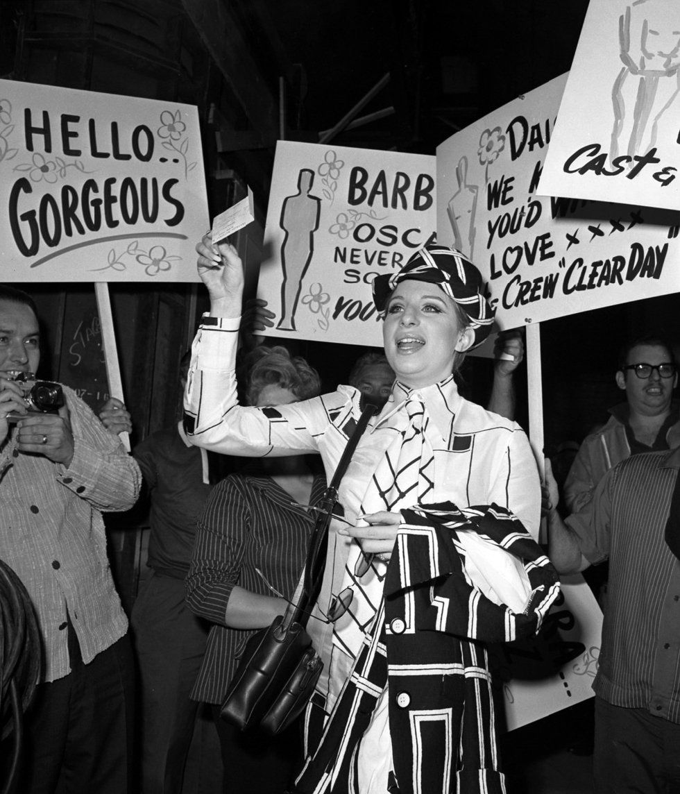 The crew of On A Clear Day hold up signs congratulating Streisand on her Oscar win.