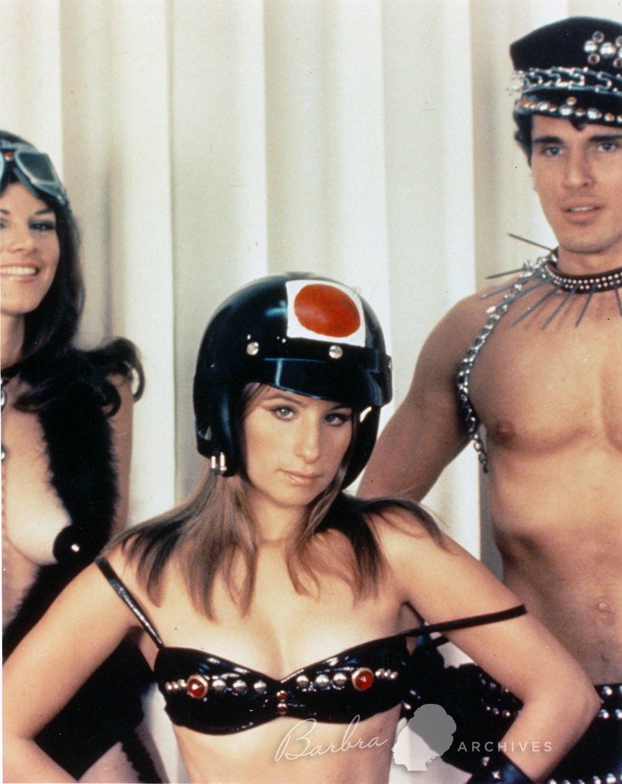A color photo of Barbra and two costars dressed as leather adult movie actors.