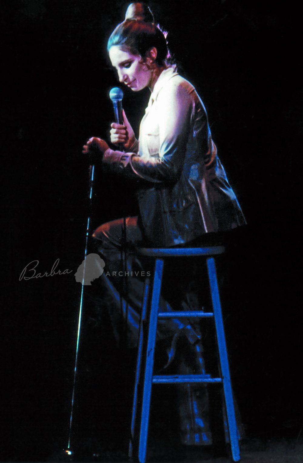 Streisand sitting on a stool at the Hilton Hotel.