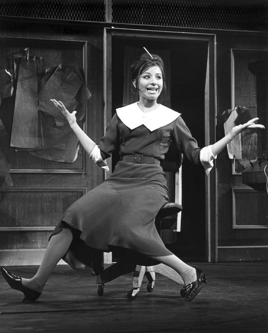 Streisand on a secretarial rolling chair