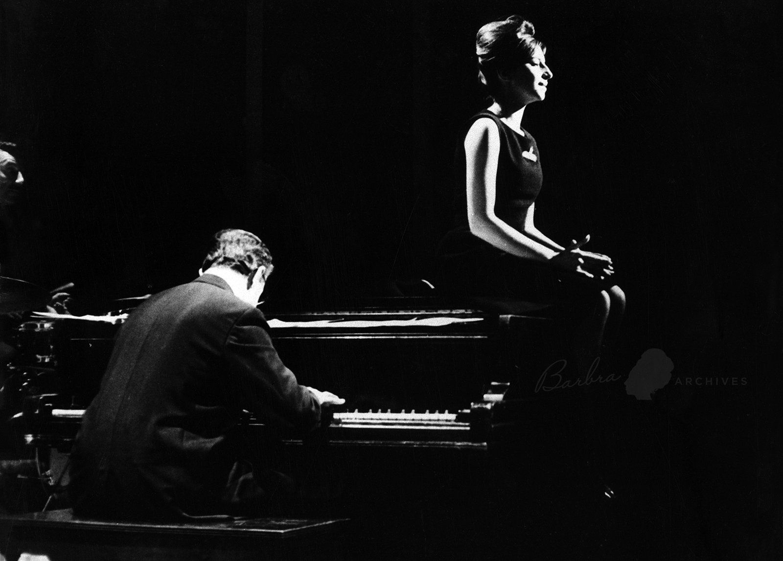 Streisand sits on the piano as she sings a song on PM East.