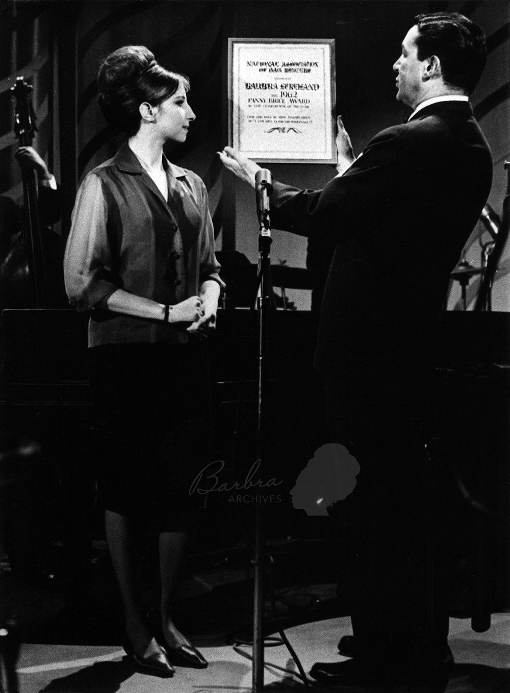 Barbra Streisand looks at the Fanny Brice Award that Mike Wallace is bestowing upon her.