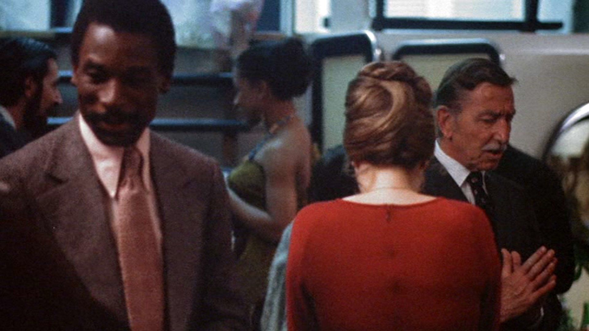 The same actor appears later at a party.