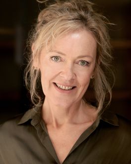 Profile photo of Ellie Nixon, a blonde woman with her hair up and smiling