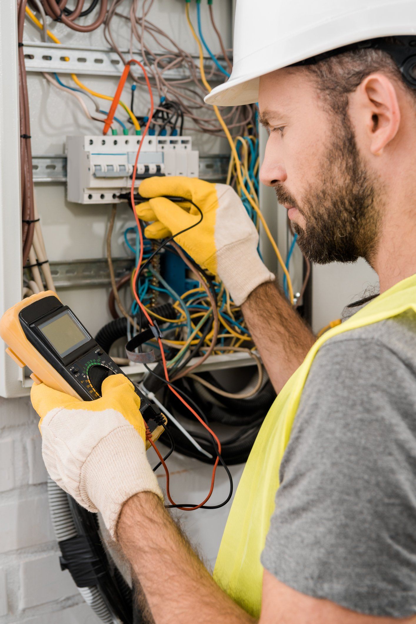 Residential Electrician — Electrician Checking Electrical Box with Multimeter in Claymont, DE Residential Electrician — Electrician Checking Electrical Box with Multimeter in Claymont, DE