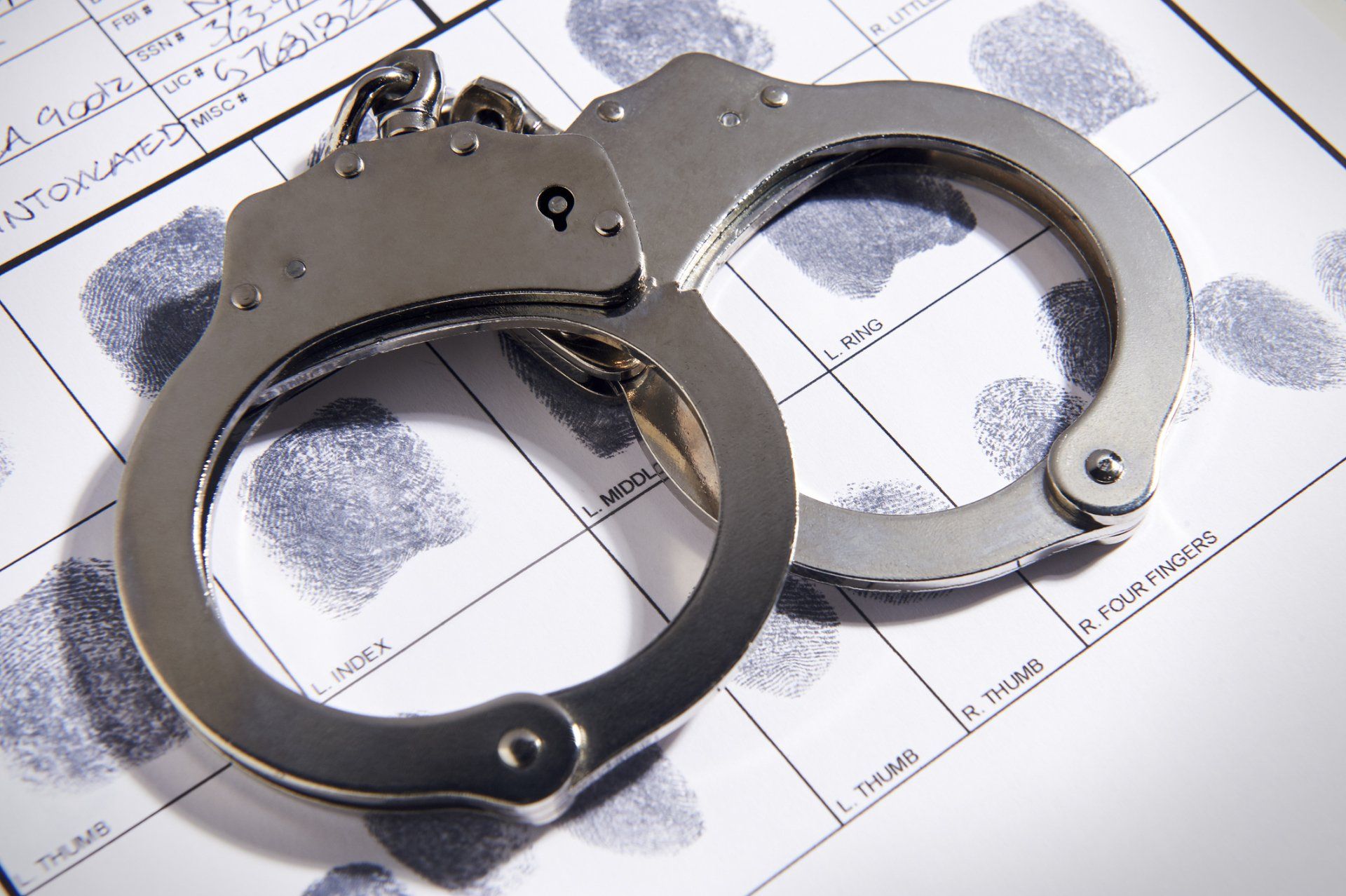 Criminal Law — Handcuffs Laying on Top of Fingerprint Chart in Wheelersburg, OH Criminal Law — Handcuffs Laying on Top of Fingerprint Chart in Wheelersburg, OH