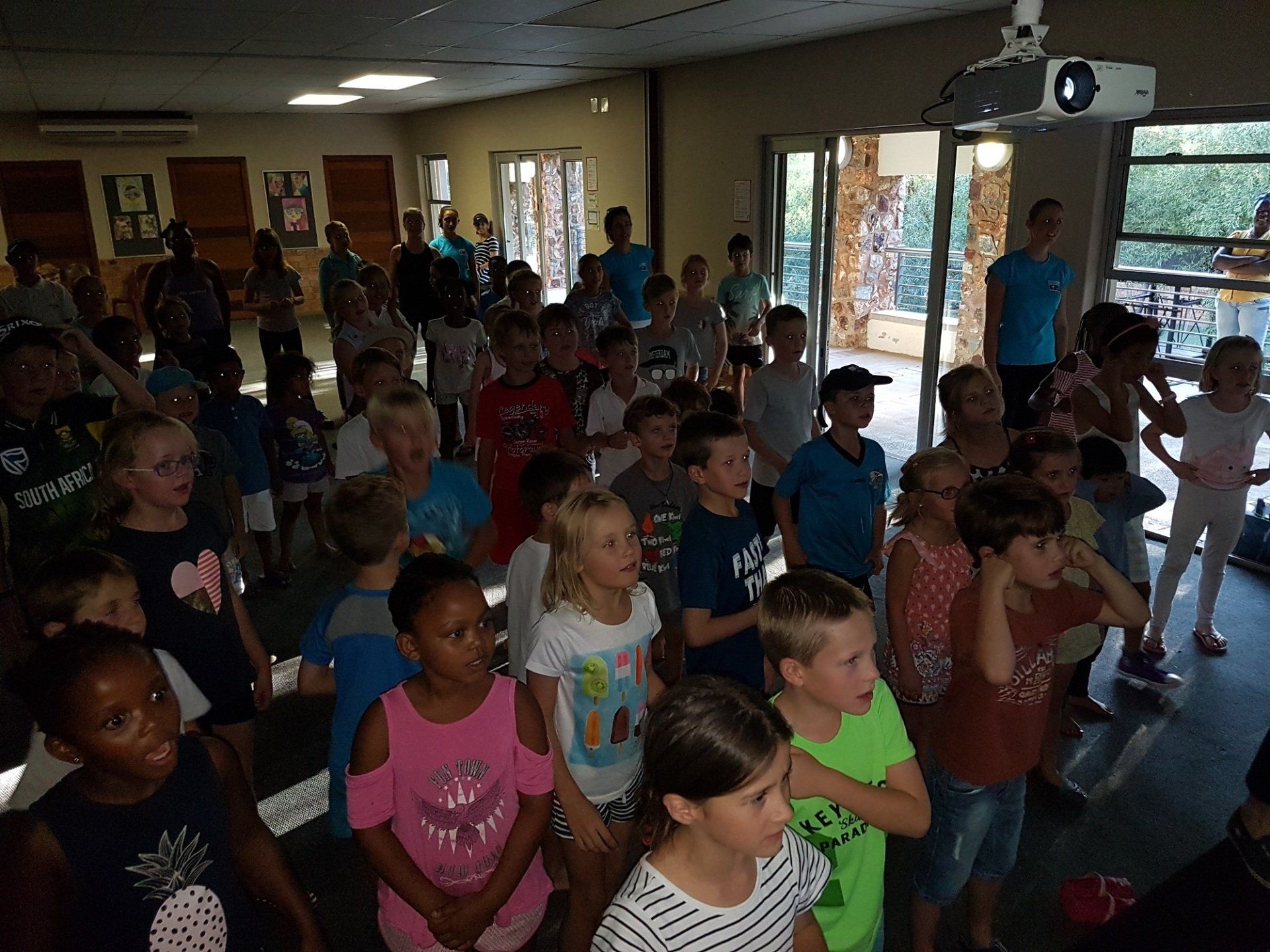 A large group of children are standing in a room.
