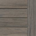 Close-up of gray-brown wood paneling with horizontal planks and a vertical trim edge