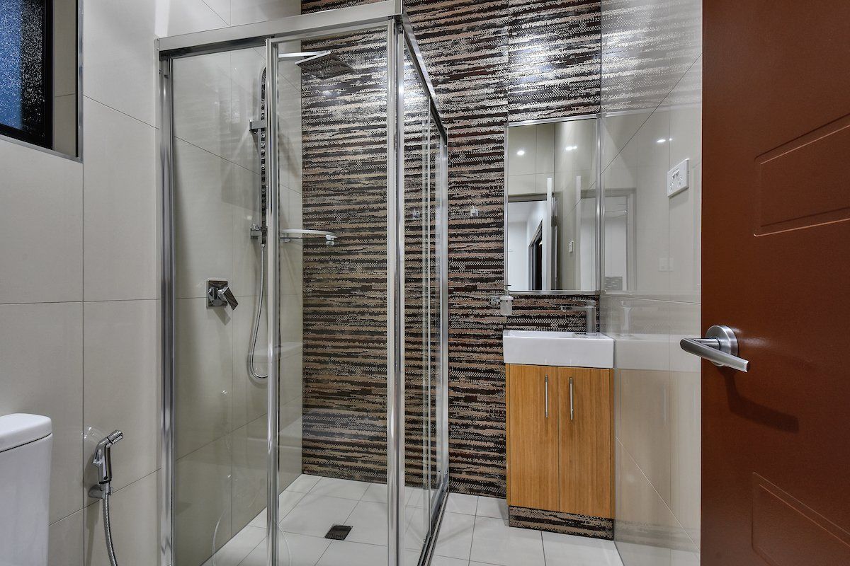 A bathroom with a walk in shower , sink and mirror.