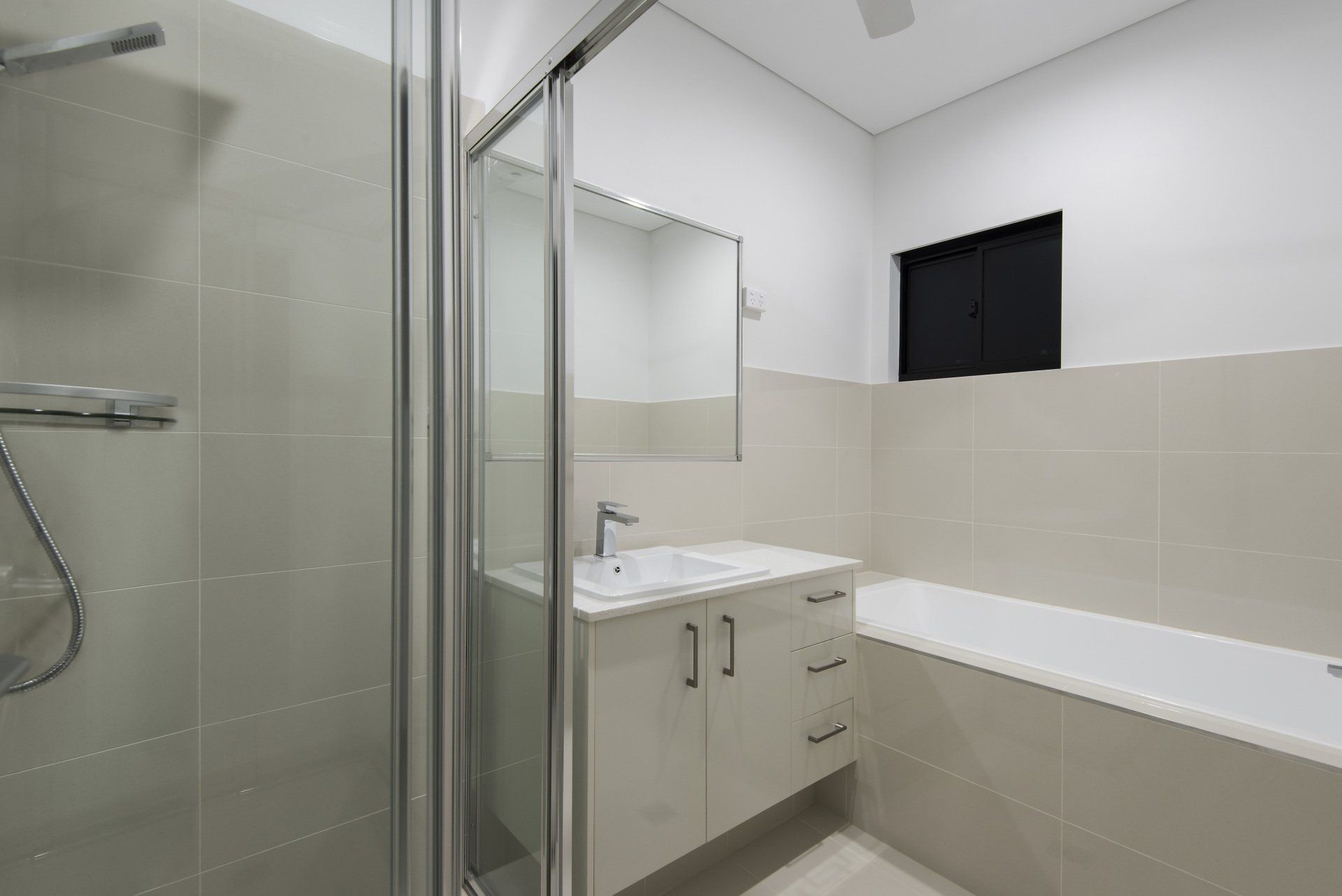 A bathroom with a sink , tub , shower and mirror.