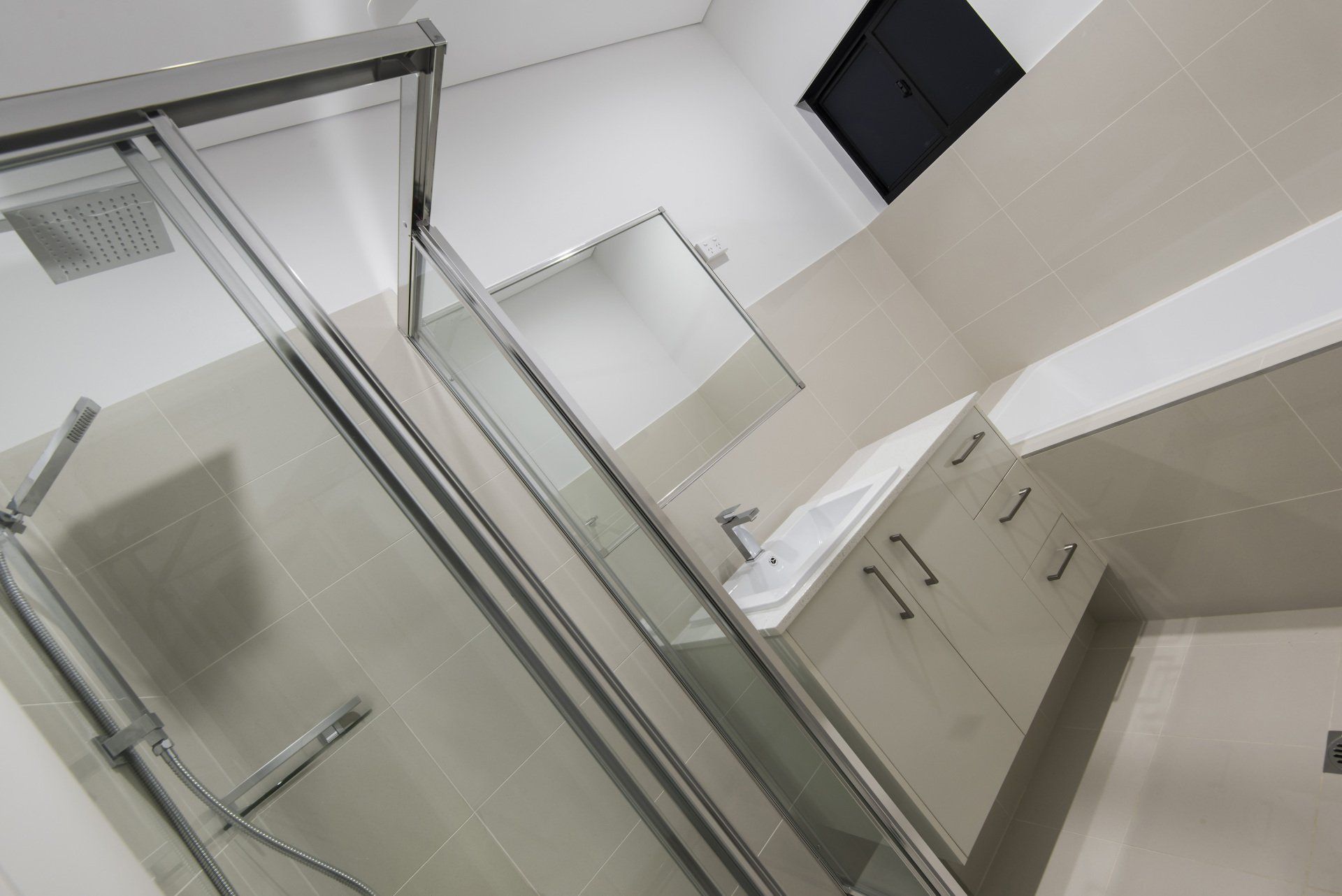 A bathroom with a sliding glass shower door and a sink