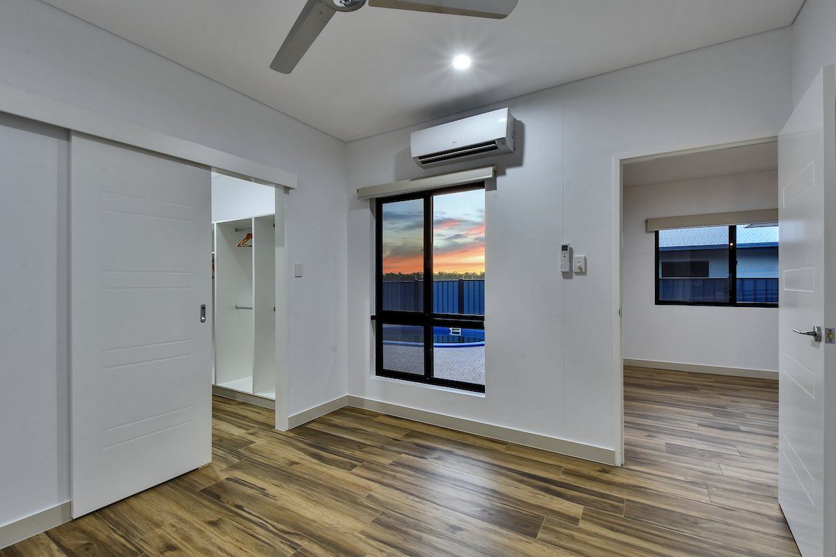 A bedroom with hardwood floors and a ceiling fan.
