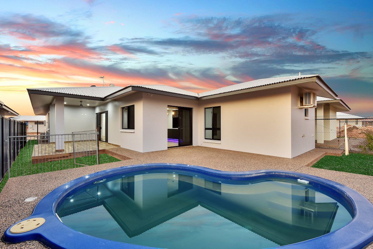 A house with a swimming pool in front of it.
