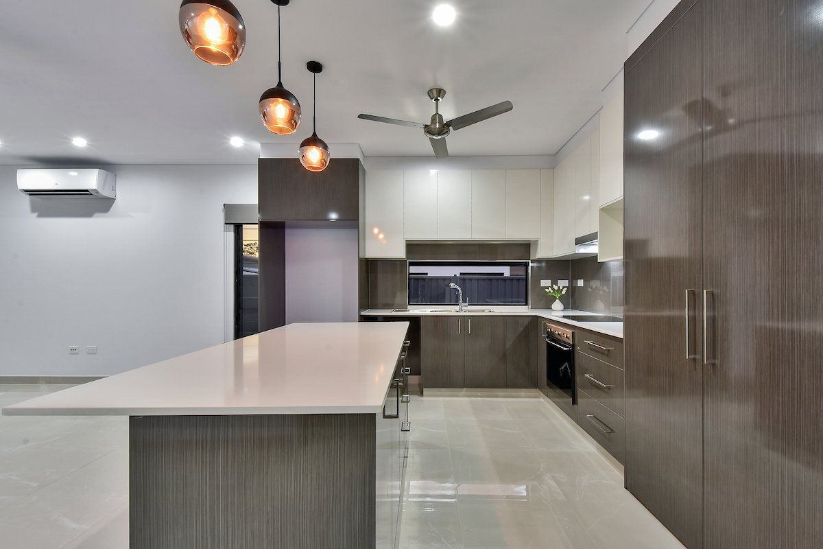 A kitchen with a large island and a ceiling fan.