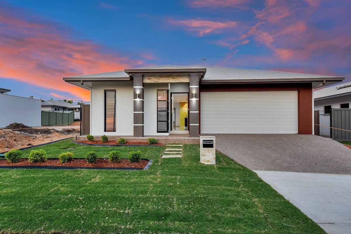 A modern house with a large lawn in front of it.