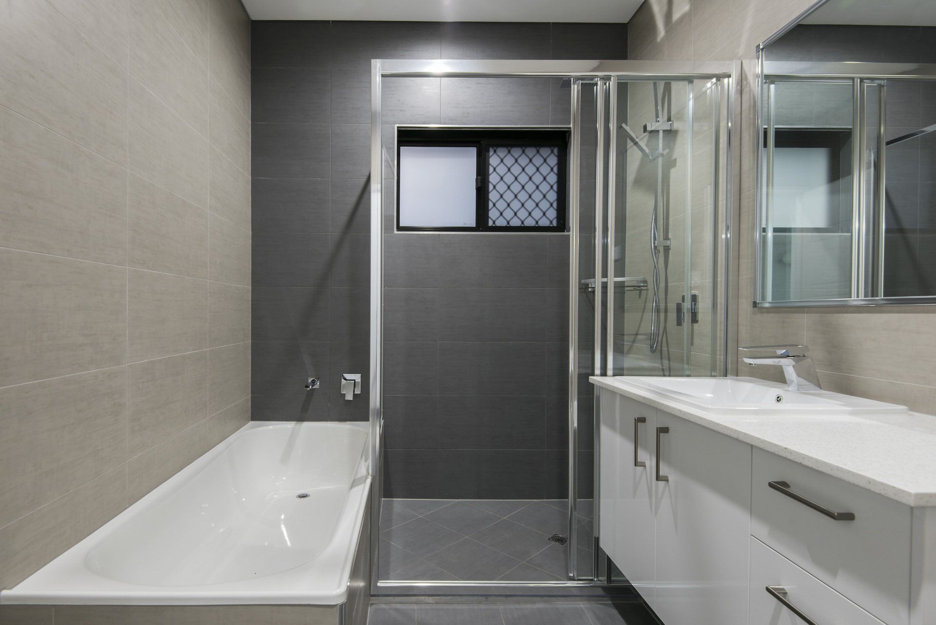 A bathroom with a bathtub , sink and shower.