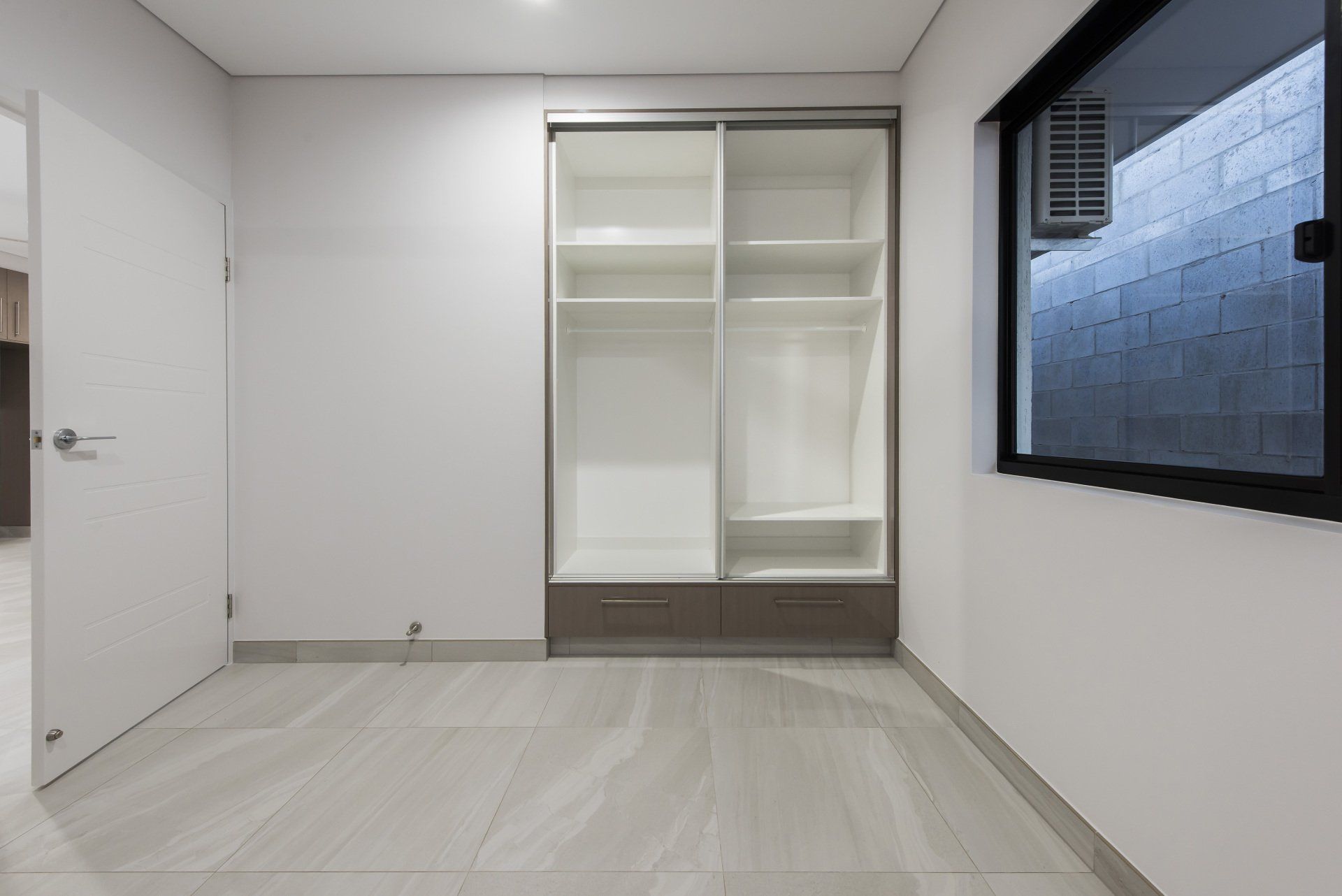An empty room with sliding doors and a window.