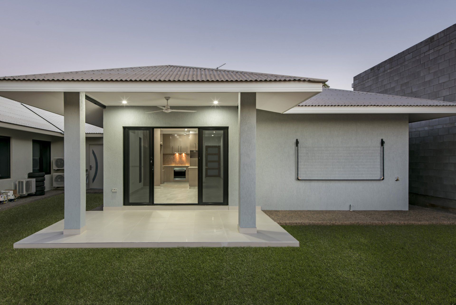 The back of a house with a patio and a sliding glass door.