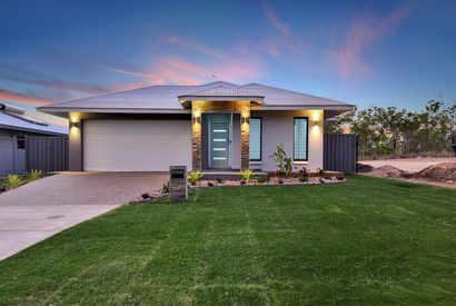 A modern house with a large lawn in front of it.