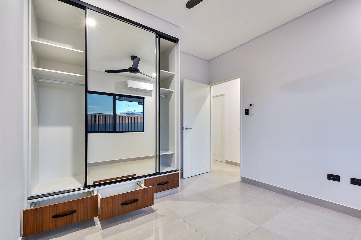 A bedroom with a ceiling fan and sliding glass doors.