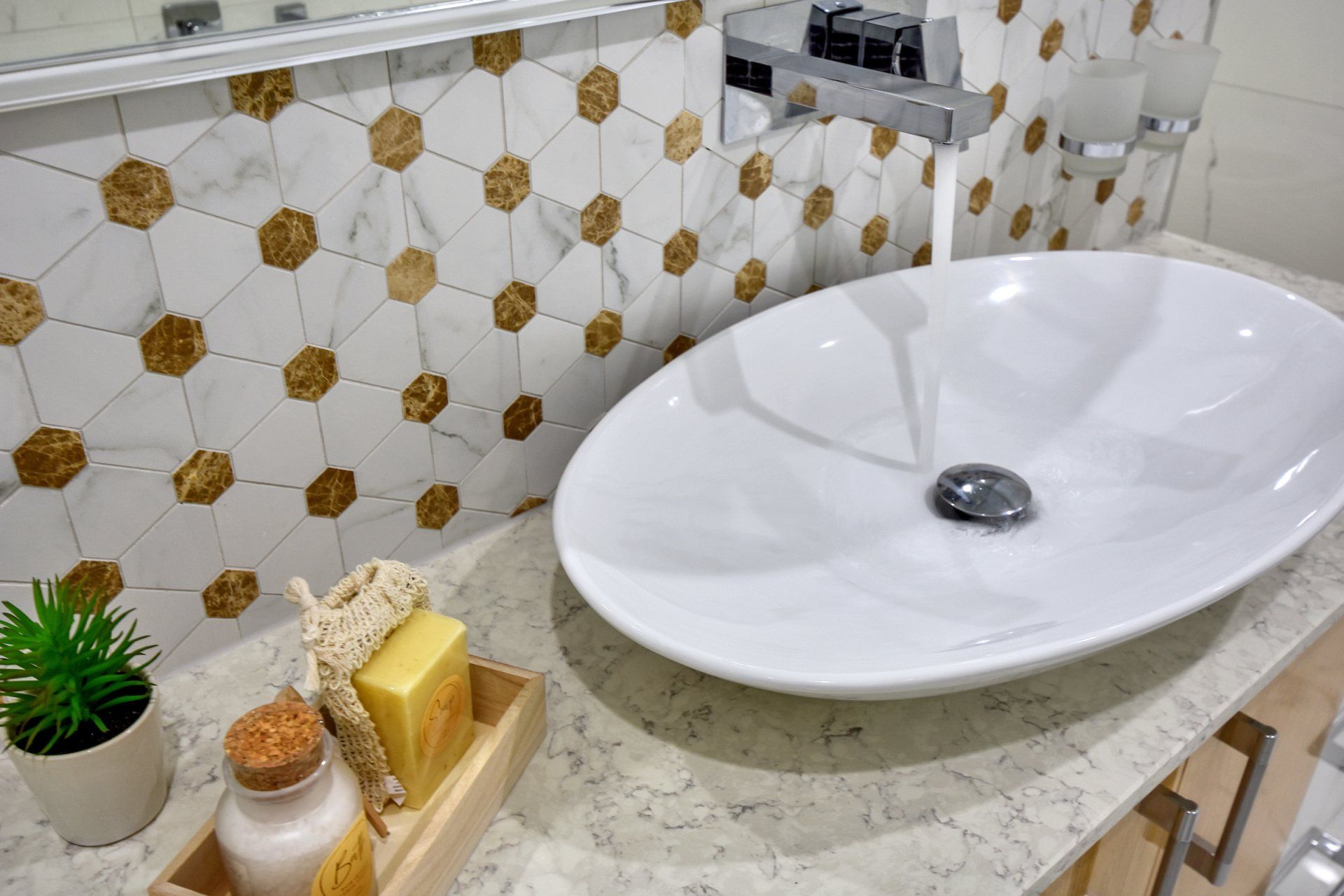 A bathroom with a sink , mirror and soap on the counter.