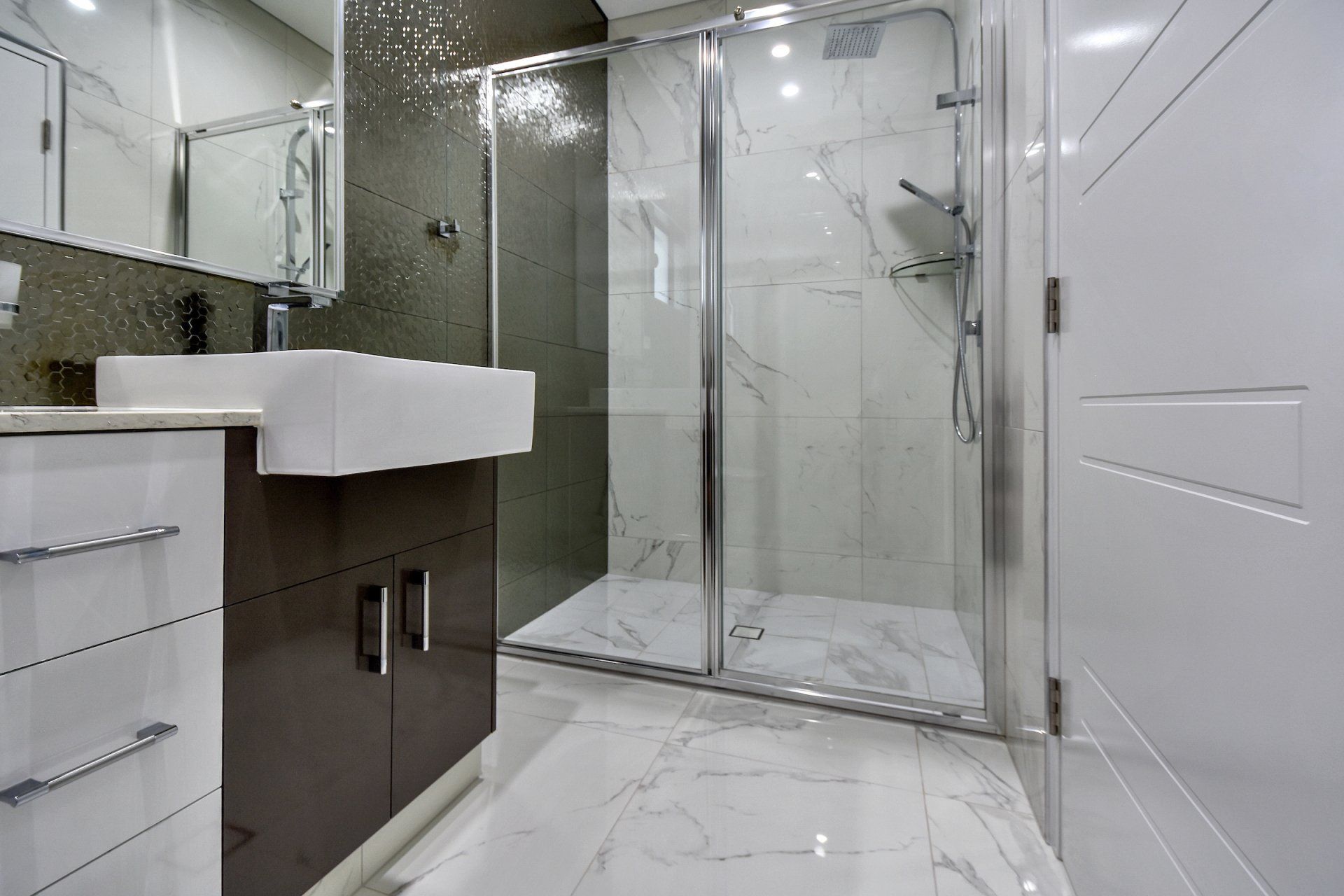 A bathroom with a sink and a walk in shower.